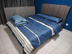 a bed with blue sheets and blue pillows on it at 马六甲Travel Serindik in Melaka +11 photos