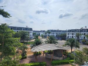 a large white building with a courtyard with palm trees at Eco BMT LUXURY HOTEL in Buon Ma Thuot +14 photos