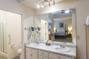 une salle de bain avec deux lavabos et un grand miroir dans l'établissement 5th Street Inn, à Mariposa