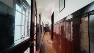 a hallway of a building with wooden floors and windows at Alleppey Houseboat Viswas Cruise in Alleppey