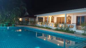 a swimming pool in front of a house at night at Pai Family House in Pai