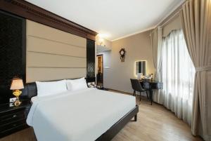 a bedroom with a large white bed and a desk at A25 Premium Hotel - 23 Quán Thánh in Hanoi
