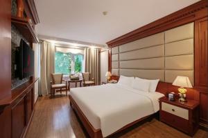 a bedroom with a large white bed and a table at A25 Premium Hotel - 23 Quán Thánh in Hanoi