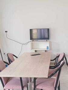 a table with chairs and a tv on top of it at javier rizzo 590 in Bahía Blanca