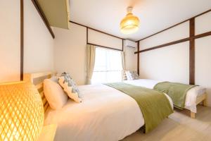 東京にあるAkisapo Stay Itabashi - アキサポステイ本蓮沼のベッド2台と窓のある寝室