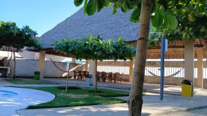 un resort con sedie e un edificio con tetto di paglia di Rancho Joya Del Mar a Sonsonate