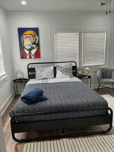 una camera da letto con un letto e un dipinto sul muro di Downtown Hideaway 1-Bedroom Bungalow a St Petersburg