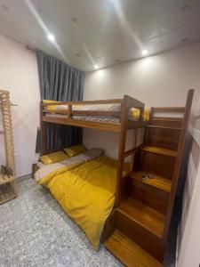 a room with two bunk beds and a yellow bed at Thương Thương Homestay in Xuan An