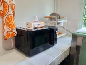 a microwave on a counter with a cake on top at Granny's home บ้านคุณย่า in Lampang
