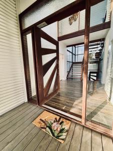 una puerta abierta en un porche con una alfombra en Sandy Escape Holiday House Kingfisher Bay Resort, en Kingfisher Bay