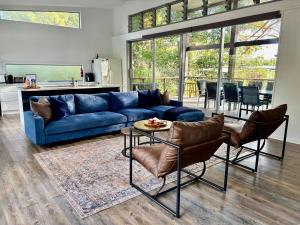 Una sala de estar con un sofá azul y una mesa. en Sandy Escape Holiday House Kingfisher Bay Resort, en Kingfisher Bay