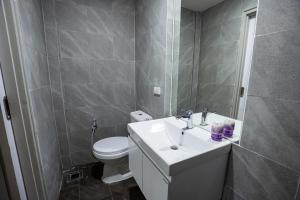 a bathroom with a white sink and a toilet at Terpenica - Rooms for Rent in Pattaya South