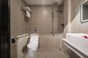 ein Badezimmer mit Toilette und Waschbecken in der Unterkunft Kly Luxury Hotel in Hue
