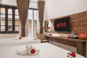 ein Hotelzimmer mit zwei Betten und einem Fernseher in der Unterkunft Kly Luxury Hotel in Hue + 32 Fotos