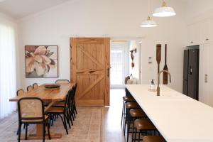 una cucina con un grande tavolo e sedie in legno di Kookaburra Beachhouse - Coastal Farmhouse Retreat a Robe