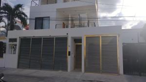 ein weißes Gebäude mit zwei Garagentoren davor in der Unterkunft Tauch Cancún Centro in Cancún