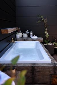 una vasca da bagno con piante in vaso in camera di Kookaburra Beachhouse - Coastal Farmhouse Retreat a Robe