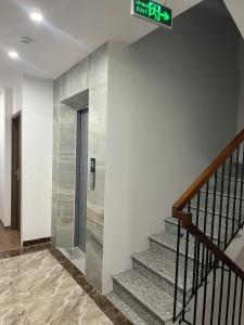a stairway with a sign on a wall and a door at Era Apartment - Chùa Láng in Hanoi +42 photos