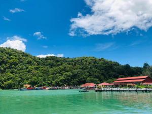 a pier with a group of boats in the water at Penarak Bamboo Beach Motel in Kuah