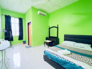 1 dormitorio con paredes verdes y 1 cama en Homestay TBK, en Kangar