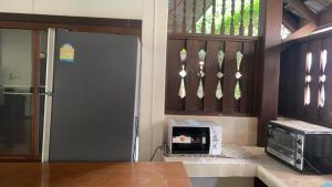a kitchen with a refrigerator and a microwave at SJ House in Chiang Mai