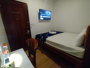 a room with a bed and a table and a tv at Senayan Stay in Jakarta