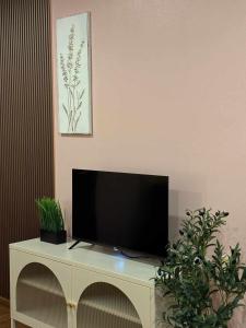 a flat screen tv sitting on top of a white cabinet at Comfy family room hatyai in Ban Khlong Pleo