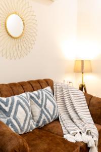 a mirror on the wall above a couch with pillows at zest living sector 55 in Gurgaon +45 photos