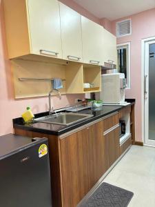 a kitchen with a sink and a microwave at Comfy family room hatyai in Ban Khlong Pleo