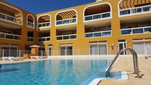 a swimming pool in front of a building at Residencial Cotillo Playa in El Cotillo