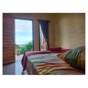 a bedroom with a bed and a large window at Middle rooms surfhomestay in Airsatang