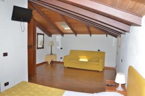 sala de estar con sofá amarillo y TV en Locanda Dal Moccia, en La Spezia