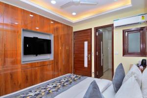 Un dormitorio con un televisor en una pared de madera. en Sleepover Inn, en Nueva Delhi 30 fotos más