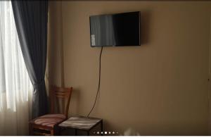 einen TV in der Ecke eines Zimmers mit 2 Stühlen in der Unterkunft Super centrally located and comfortable apartment in Cochabamba