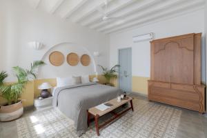 1 dormitorio con 1 cama grande y vestidor de madera en Villa Mandarina - Luxury 4BHK Villa Near Morjim Beach with Pvt Pool, Pool Table & Kids Playground, en Siolim