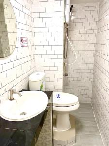 a white bathroom with a sink and a toilet at Impact Arena C75fl by GoodRoom24 in Ban Song Hong +4 photos