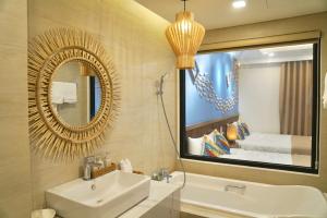a bathroom with a sink and a mirror and a bed at FLC SEATOWER Quy Nhơn in Quy Nhon +124 photos