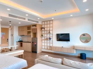 a living room with a couch and a tv on a wall at FLC SEATOWER Quy Nhơn in Quy Nhon