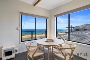ein Esszimmer mit Tisch und Stühlen und dem Meer in der Unterkunft See-Sea House - Sellicks Beach - C21 SouthCoast Holidays in Sellicks Beach