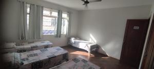 a living room with two beds and a window at Hospedaria Central in Lavras