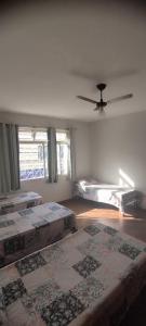 a bedroom with three beds and a ceiling fan at Hospedaria Central in Lavras +46 photos