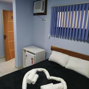 a bedroom with a bed with two towels on it at Suítes da lagoa monte alto in Arraial do Cabo
