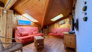 ein Wohnzimmer mit zwei roten Stühlen in einem Haus in der Unterkunft Appartement Proche Des Pistes in Saint-Gervais-les-Bains
