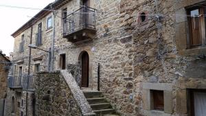 Edificio de piedra antiguo con escaleras y balcón en Traditional sicilian home, en Mistretta