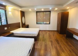 Habitación con 2 camas, suelo de madera y ventana. en Homestay Sapa, en Sa Pa