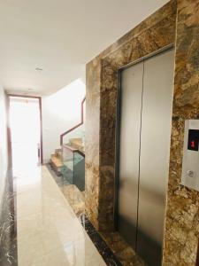 Un vestíbulo con ascensor y una pared de piedra. en Homestay Sapa, en Sa Pa