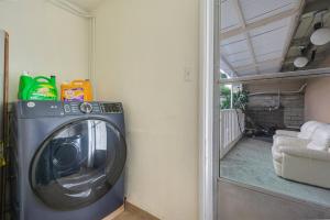 a washing machine in a room with a living room at Newly Renovated Home Spacious Close 2 Hospital in San Bernardino