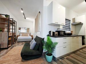 a living room with a couch and a kitchen at Fly Away Home condo with terrace in Qormi