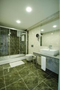 a bathroom with a tub and a sink and a toilet at Cimenoglu Hotel in Denizli