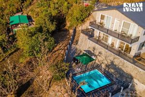 an overhead view of a house with a swimming pool at StayVista at Sunset Springs with Heated Swimming Pool in Nainital